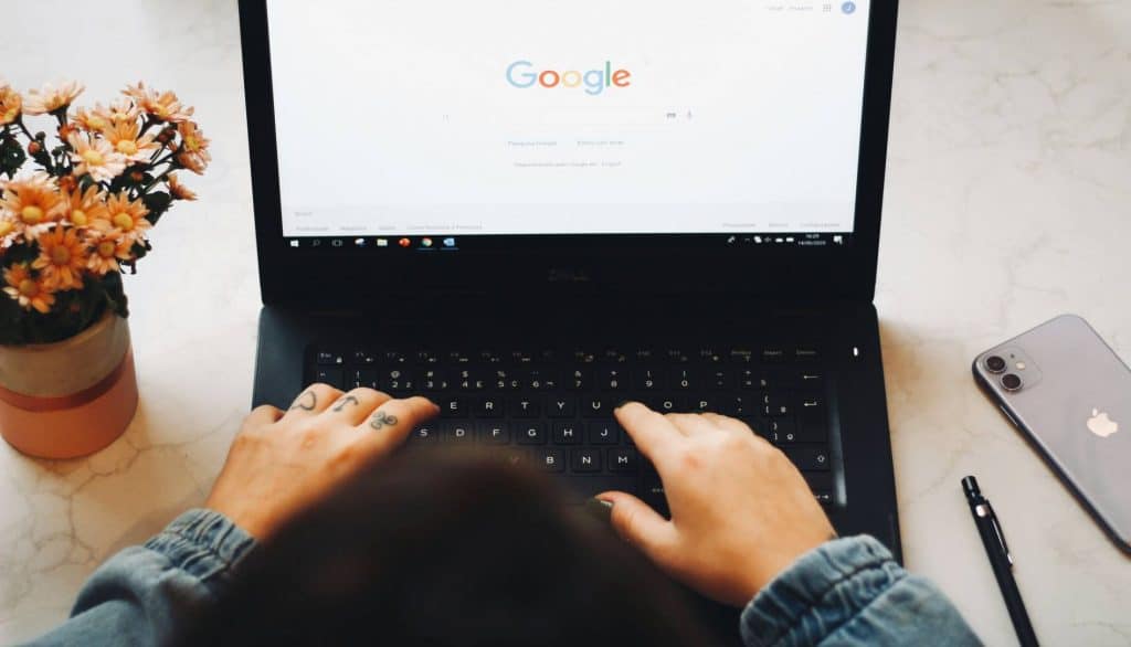 Two hands typing on a laptop keyboard,