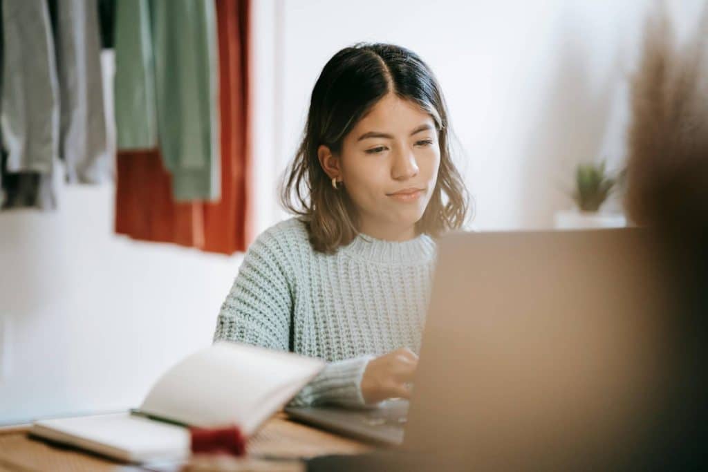 Young woman typing on a laptop.