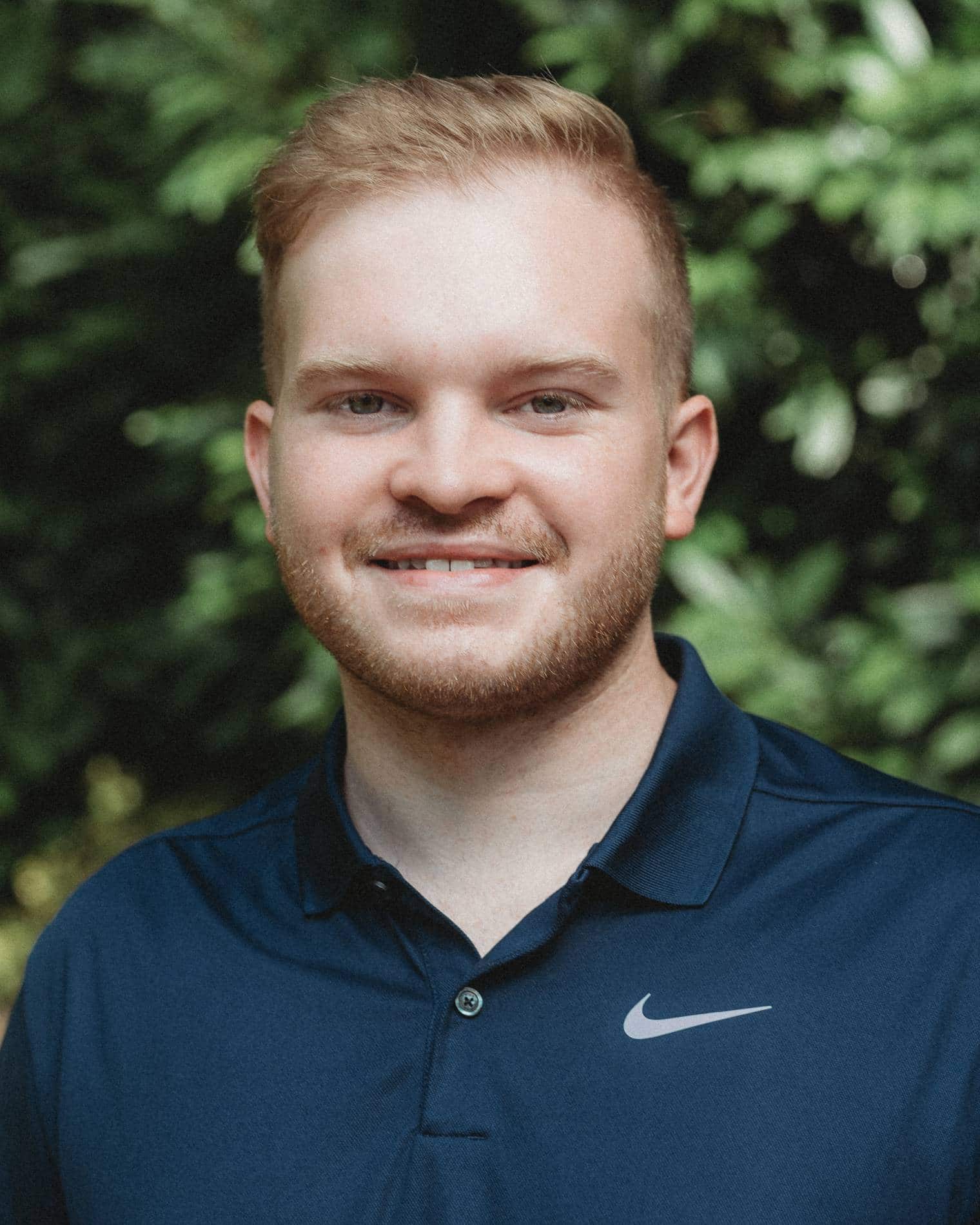 Chase Kalishek wearing a dark polo and smiling.