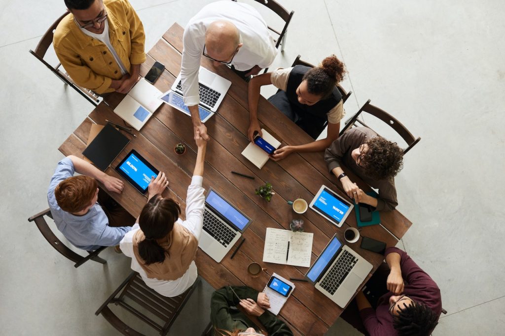 Bird's eye view of professionals handshaking across a table